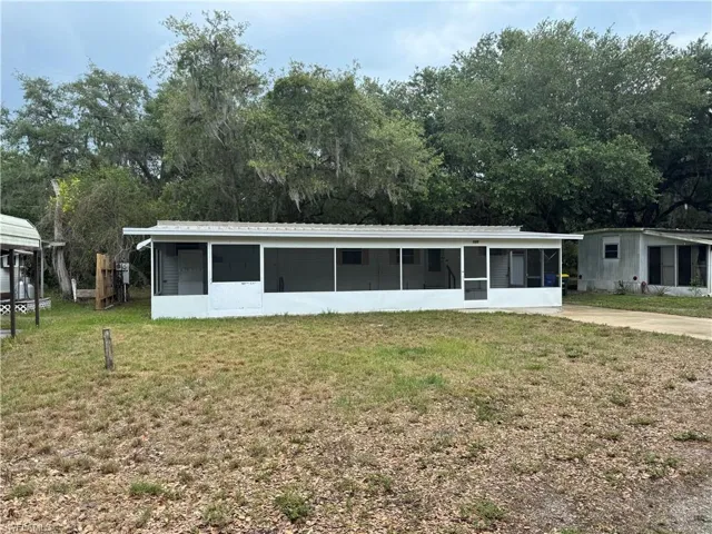 View of front facade featuring a front yard and a sunroom