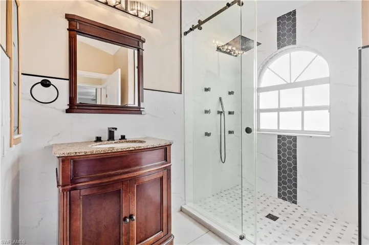 Guest bath with a marble finish shower and vanity