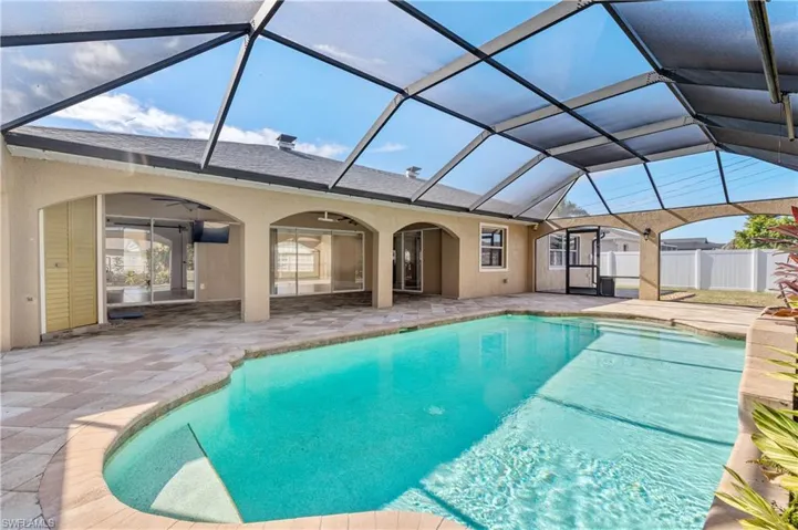 Outdoor pool with a sunroom, a patio area, and a lanai