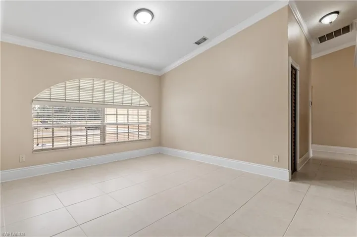 Spare room featuring ornamental molding and light tile patterned floors