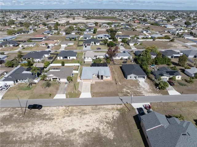 Aerial view of property and surrounding area featuring nearby suburban area