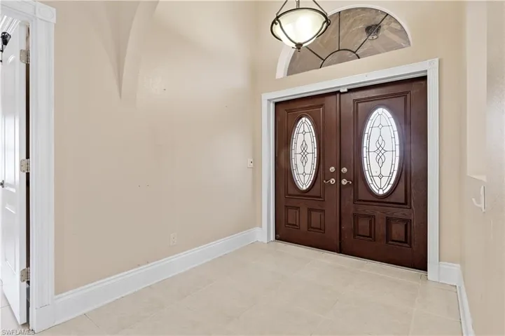 Foyer featuring light tile patterned flooring and a high ceiling