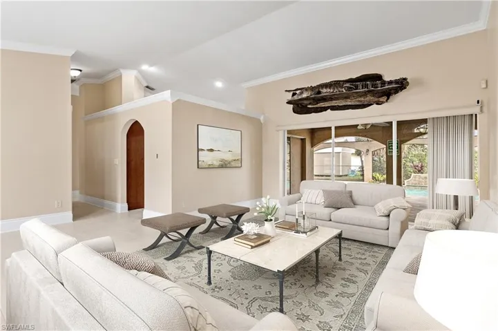 Living area featuring crown molding, arched walkways, and recessed lighting