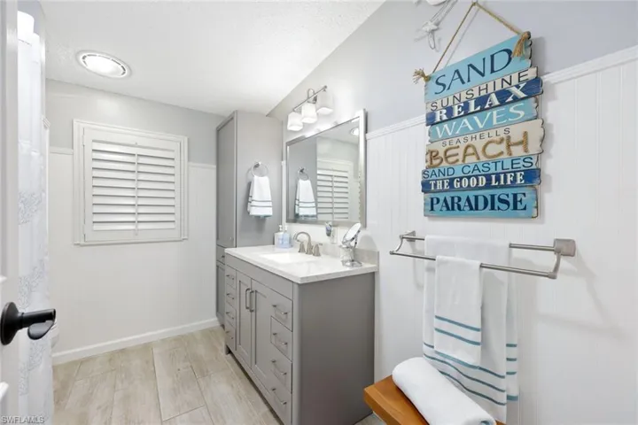 Bathroom with a textured ceiling, vanity, and hardwood / wood-style flooring