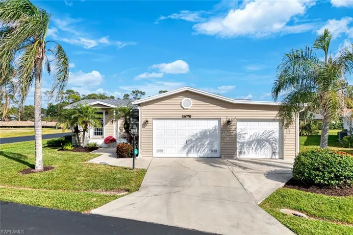 Single story home featuring a front yard and a garage