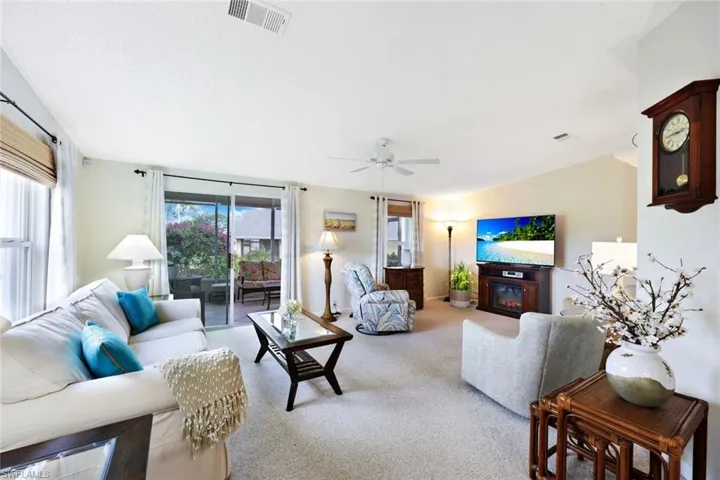 Carpeted living room featuring ceiling fan