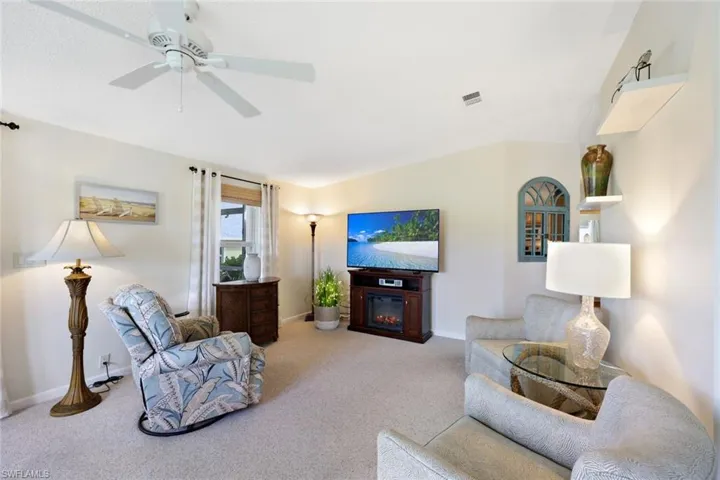 Carpeted living room with ceiling fan