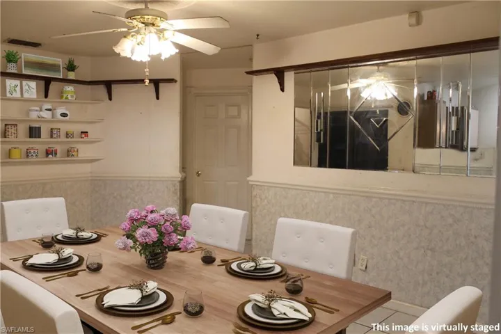 Dining room featuring a ceiling fan and wainscoting
