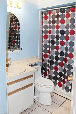 Bathroom with a shower with shower curtain, vanity, and light tile patterned floors