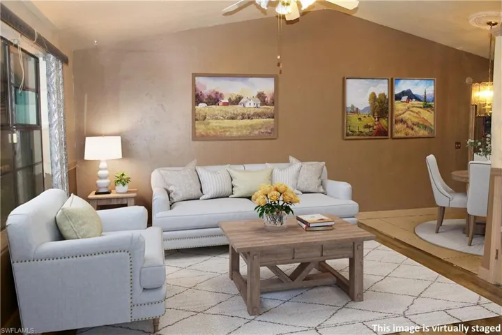 Living area with vaulted ceiling, wood finished floors, and a ceiling fan