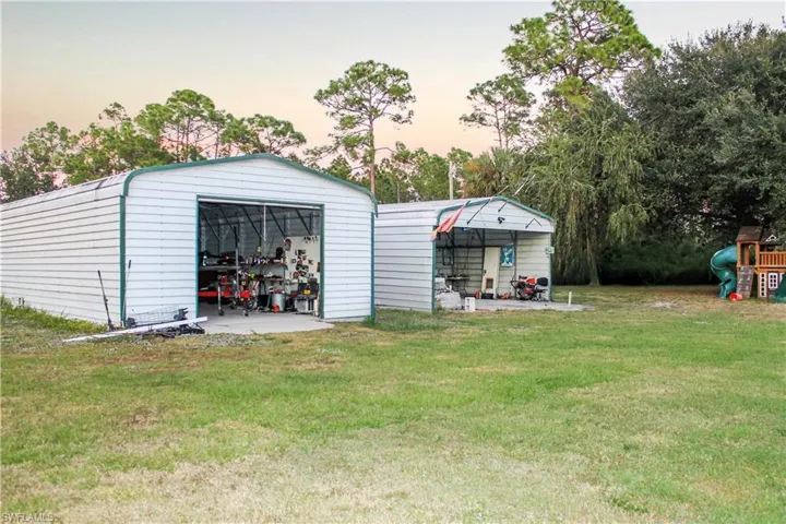View of outdoor structure featuring a playground and view of wooded area