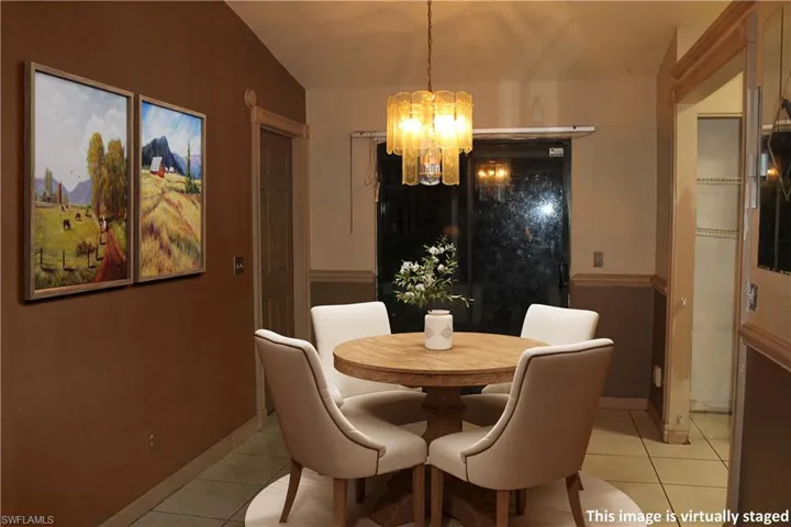 Dining area featuring light tile patterned floors and a chandelier