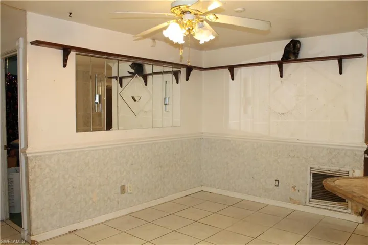 Unfurnished dining area featuring heating unit, tile patterned floors, and a ceiling fan