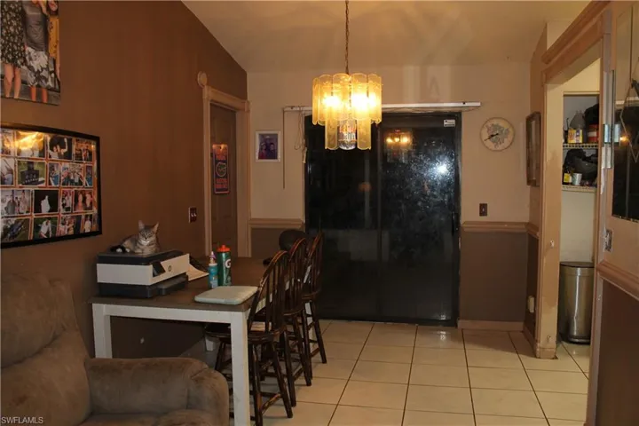 Dining space with a chandelier and light tile patterned flooring