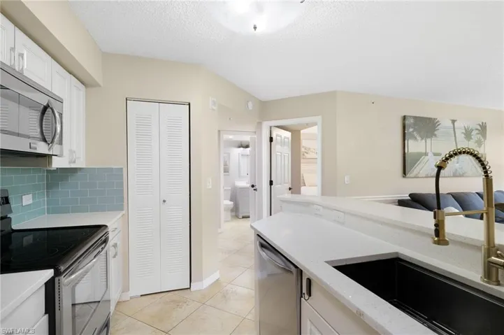 Kitchen with Pantry with Shelving. View also to Full Bath with Direct Access to Bedroom.