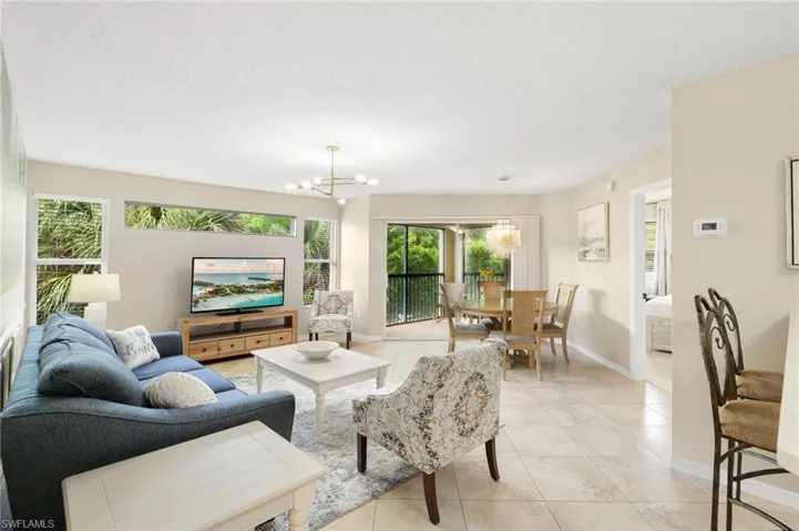Open Great Room Spaces with Breakfast Bar, Dining Area and Slider to Screened Balcony