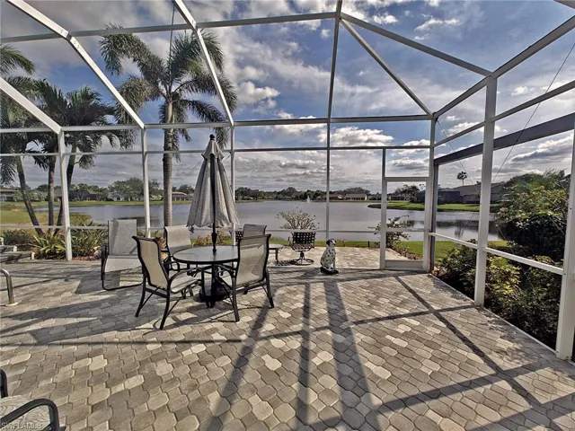 View of patio / terrace featuring glass enclosure and a water view
