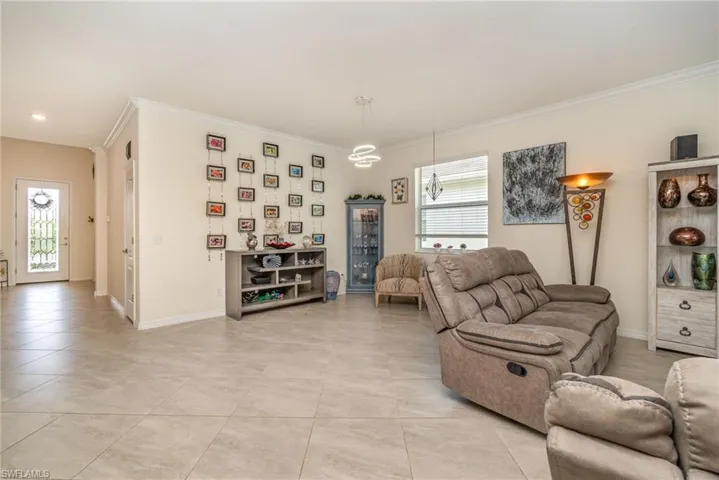 Tiled living room with crown molding and a wealth of natural light