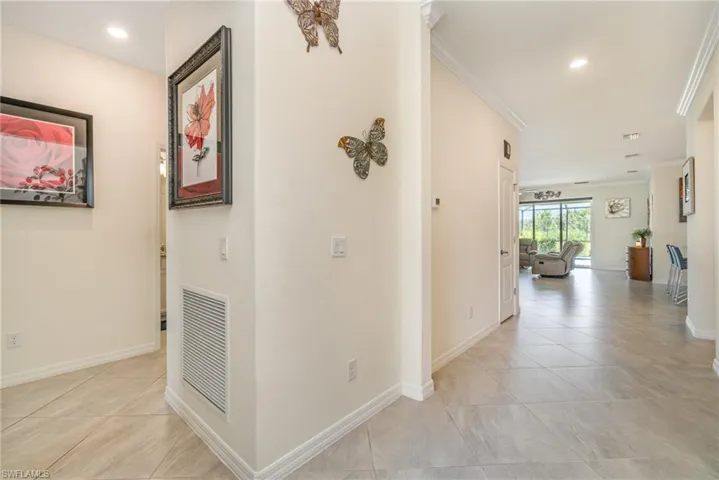 Hallway featuring light tile patterned floors and ornamental molding