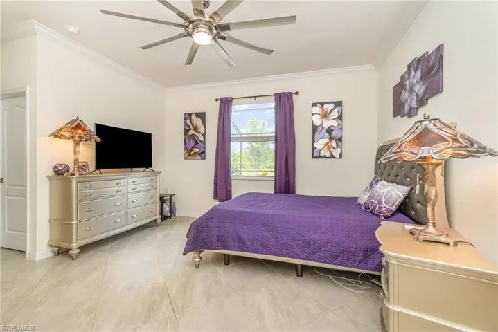 Tiled bedroom featuring crown molding and ceiling fan