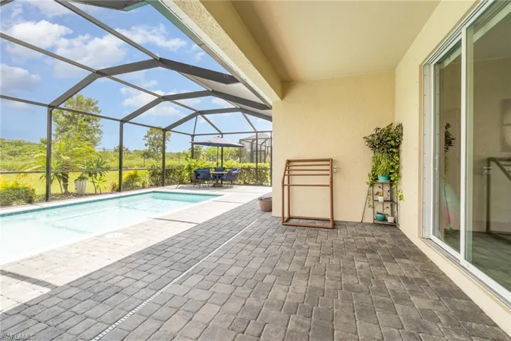 View of swimming pool with a patio and glass enclosure