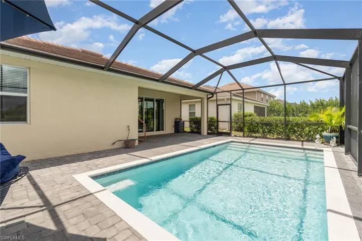 View of swimming pool with a patio area and glass enclosure