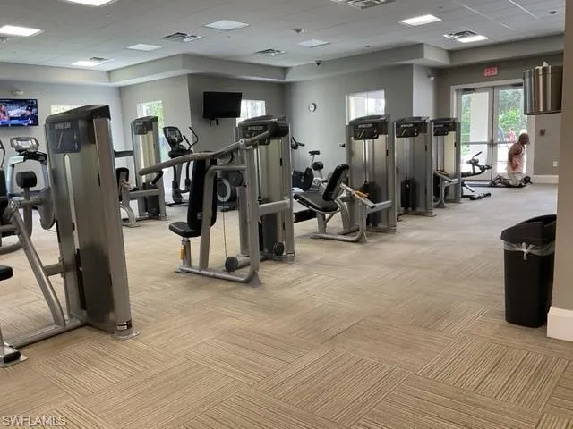 Gym featuring a drop ceiling and light carpet