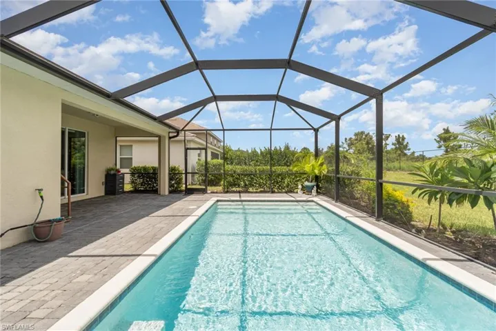 View of pool with a patio area and a lanai