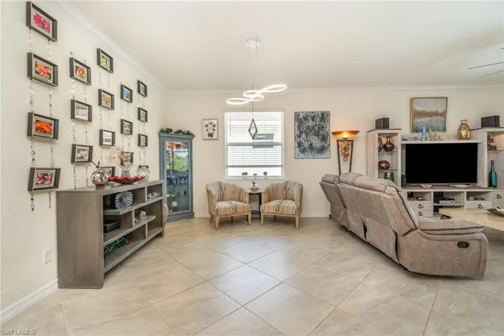 Tiled living room featuring crown molding