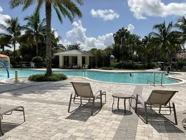 View of pool with a patio area and pool water feature