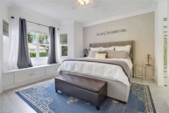Bedroom with ornamental molding, ceiling fan, and light hardwood / wood-style floors