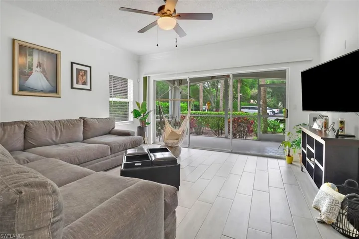 Living room with plenty of natural light, a textured ceiling, and ceiling fan