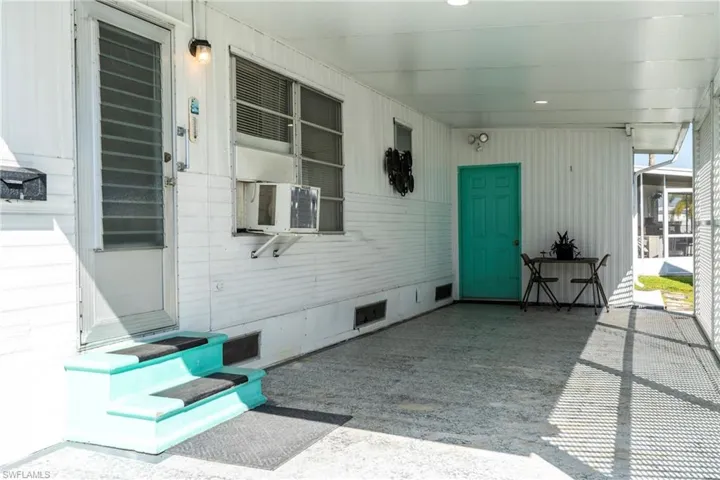 View of paved carport area with entrance door
