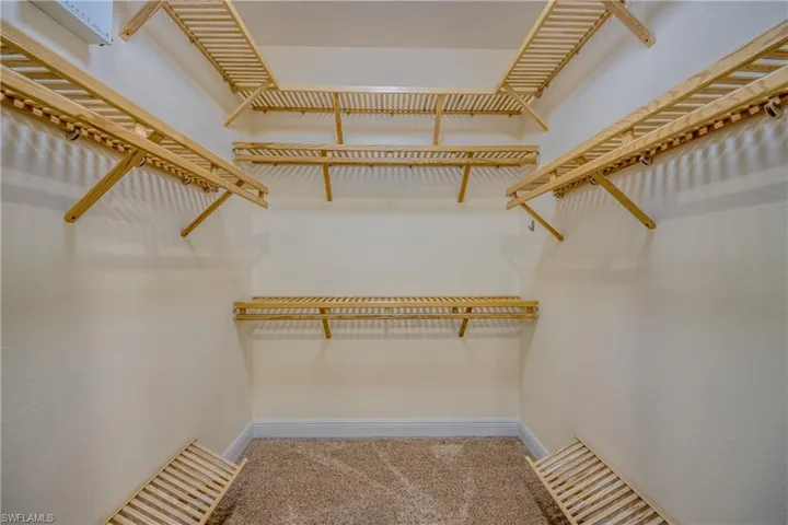 Spacious owner's closet with custom wood shelving.