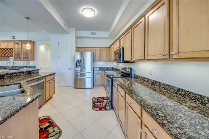 Gorgeous kitchen, rich wood cabinets, double sink & high faucet.