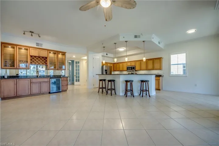 Huge great room looking at custom wet bar, kitchen & foyer.
