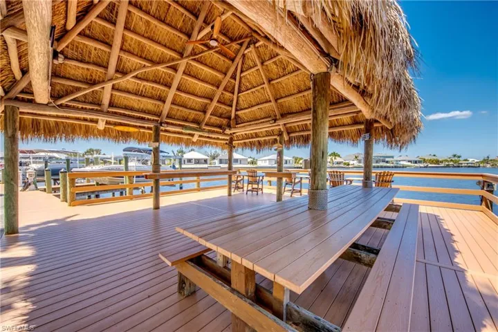 Under gorgeous tiki hut with benches to enjoy & relax.