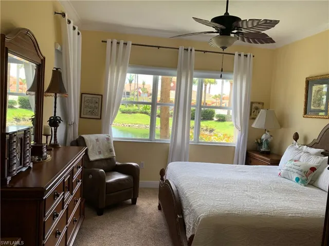 Owner's spacious bedroom with crown molding & private French door to Lanai with fantastic view of lake with fountain! (furnished before sellers move out)