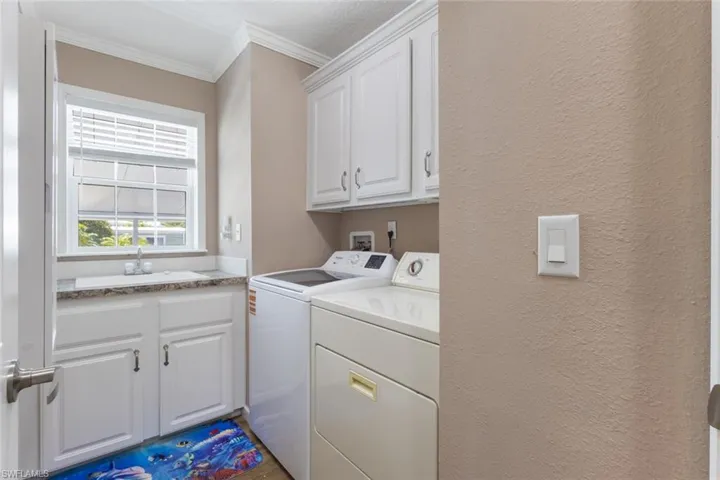 Walk-in laundry with plentiful storage, full size sink.