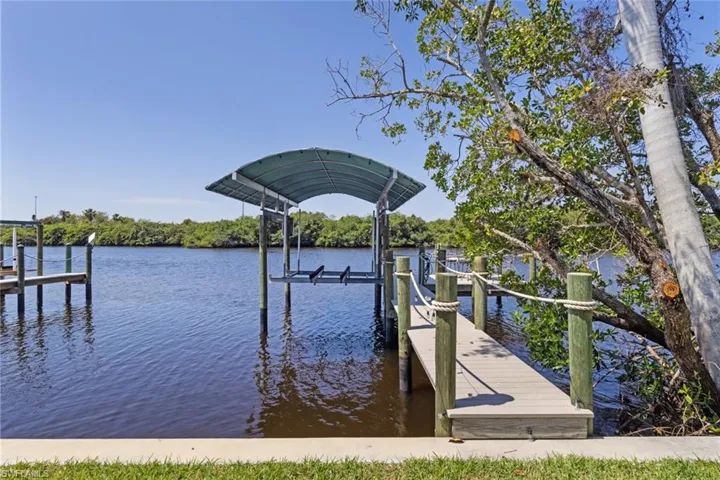 Updated Covered Boat Dock (2022) with Captain's Walk, extended dock with seating, electric, and water