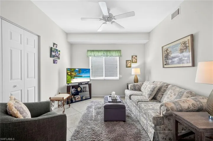 Living room featuring ceiling fan and tile patterned floors