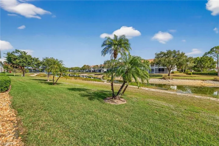 View of home's community with a water view and a lawn