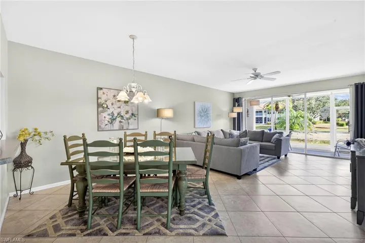 Dining room with a chandelier, light tile patterned floors, and ceiling fan