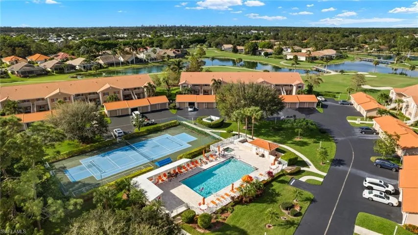 Aerial view of residential area featuring a pool area and a nearby body of water