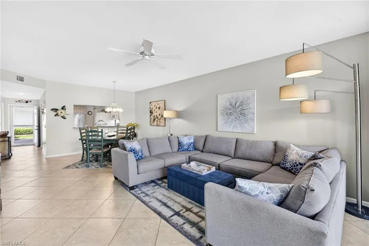 Living room with light tile patterned floors and ceiling fan