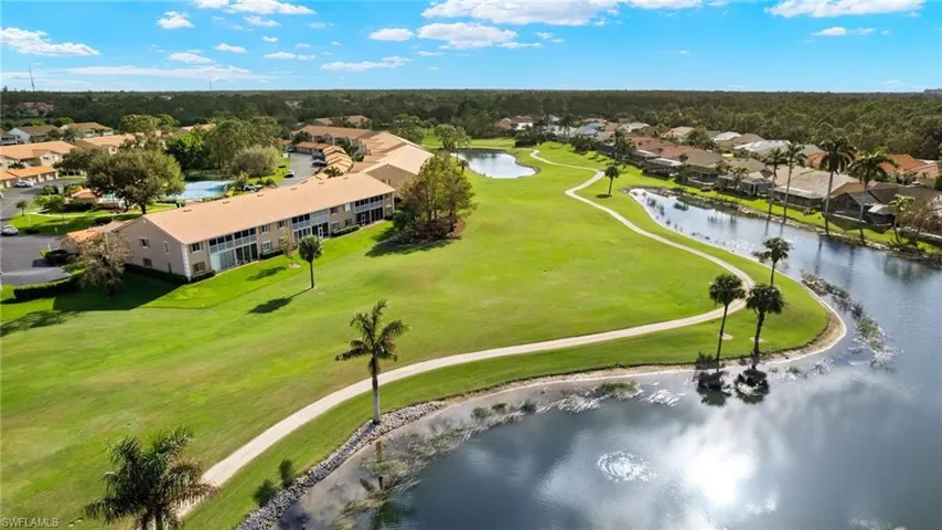Aerial view of residential area featuring a nearby body of water and a local golf course