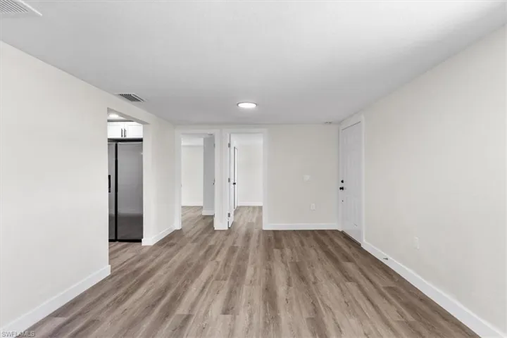 Empty room with hardwood / wood-style flooring