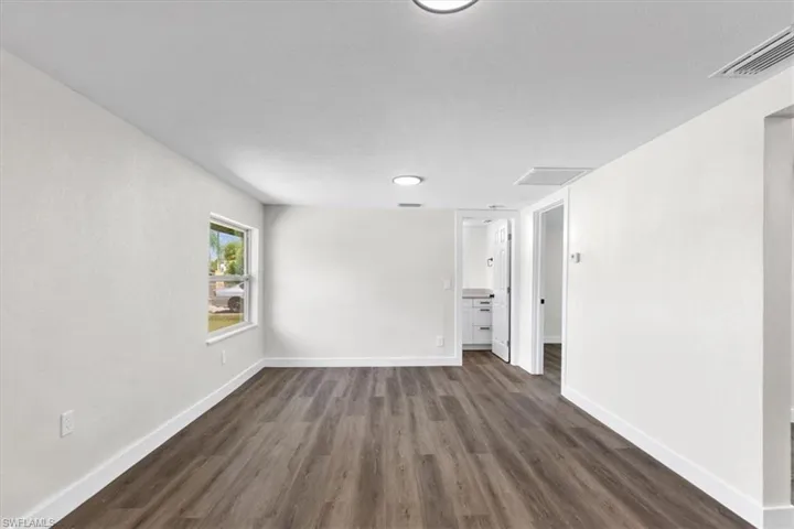 Spare room with dark wood-type flooring