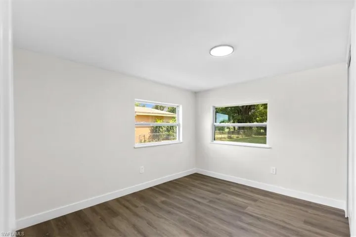 Empty room featuring dark wood-type flooring