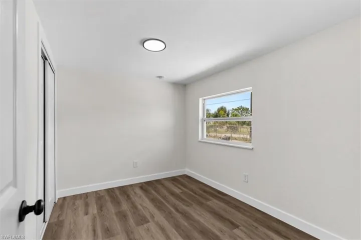 Empty room with hardwood / wood-style floors